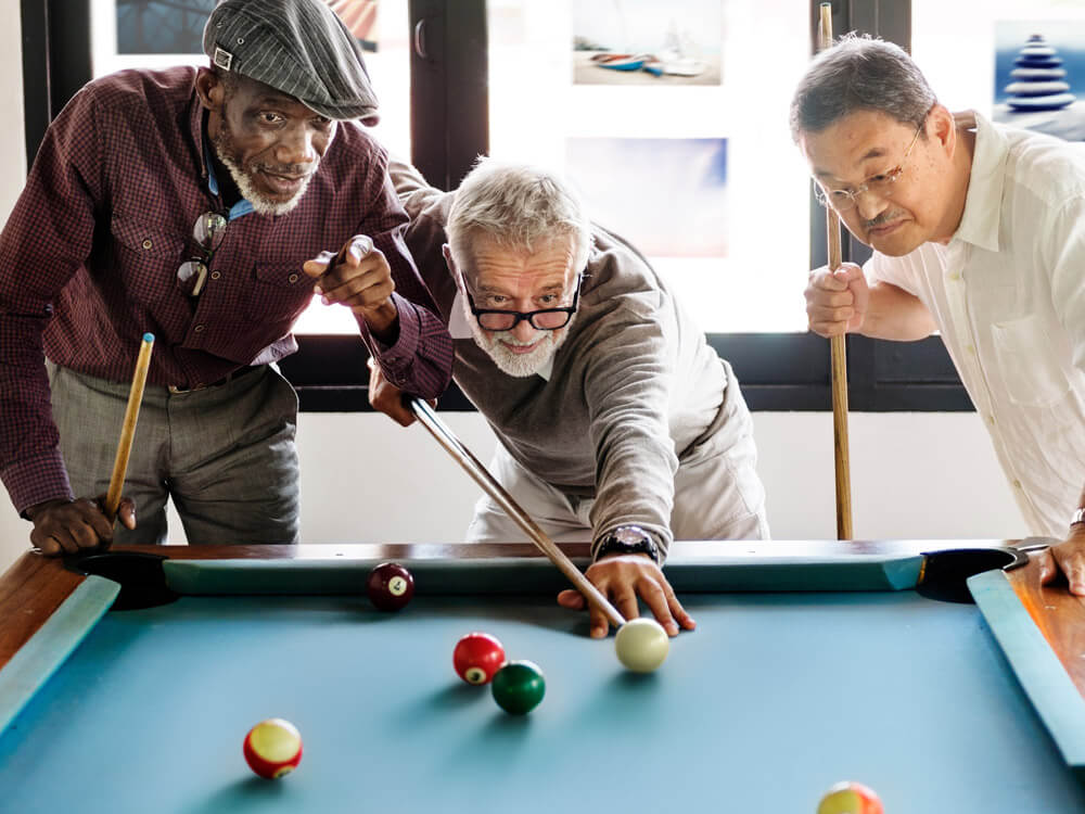 Retired friends playing pool at the clubhouse